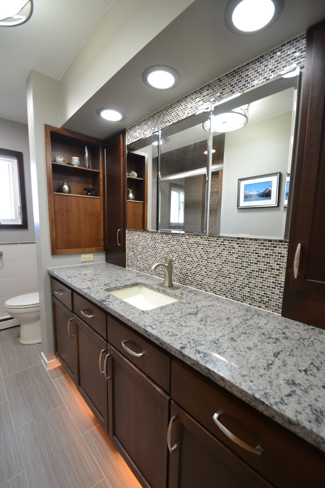 Example of a small transitional master gray tile and subway tile laminate floor and gray floor bathroom design in Charlotte with flat-panel cabinets, dark wood cabinets, a one-piece toilet, gray walls, a drop-in sink and quartzite countertops