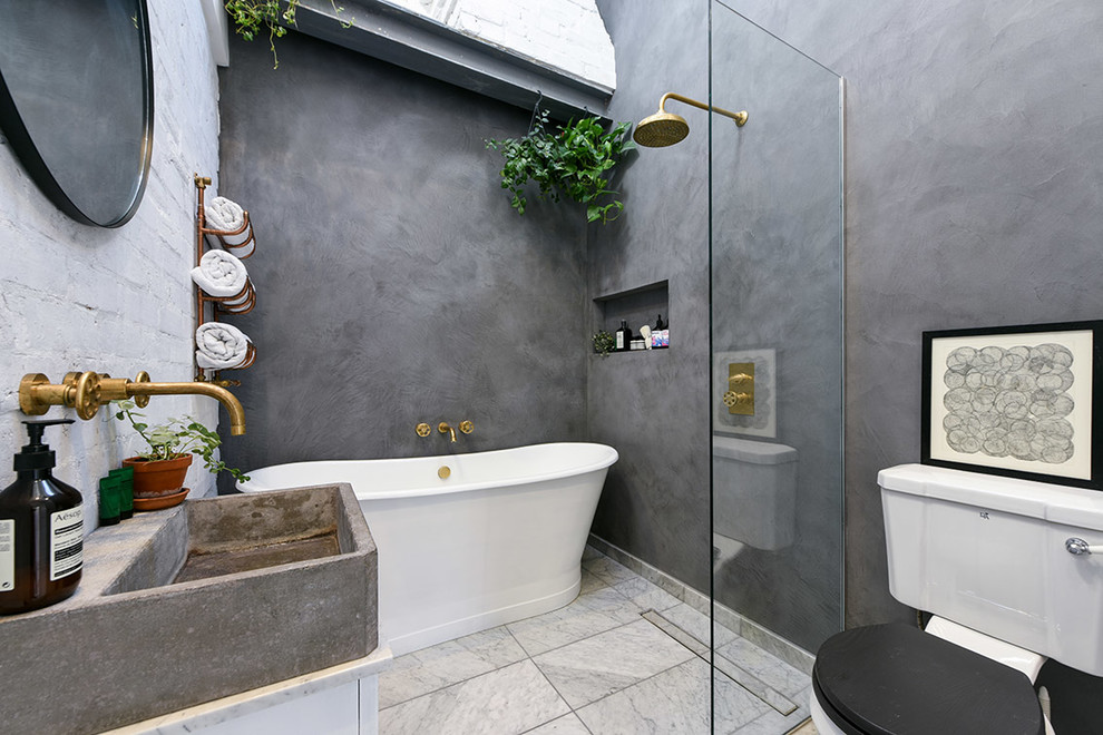This is an example of a medium sized contemporary wet room bathroom in London with flat-panel cabinets, white cabinets, a freestanding bath, a two-piece toilet, grey walls, marble flooring, a vessel sink, grey floors and an open shower.