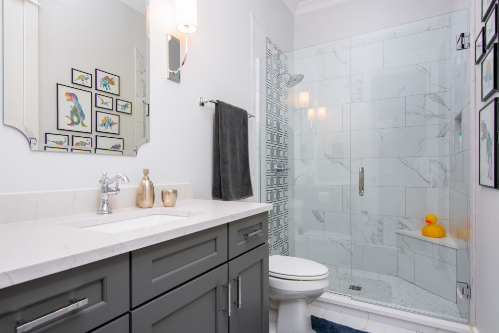 Example of a beach style white tile single-sink alcove shower design in Nashville with shaker cabinets, gray cabinets, white walls, an undermount sink, a hinged shower door, white countertops and a built-in vanity