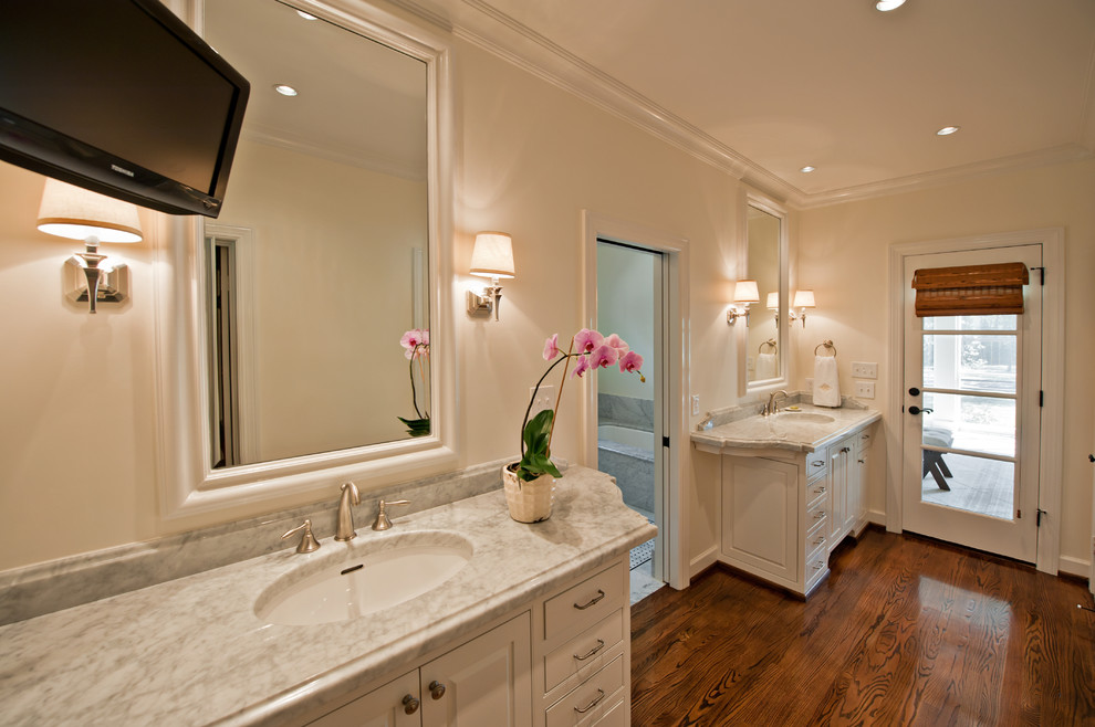Foto di un'ampia stanza da bagno padronale classica con lavabo integrato, ante con bugna sagomata, ante bianche, top in marmo, pareti bianche e pavimento in legno massello medio
