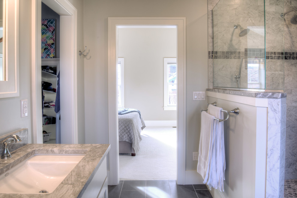 Lantlig inredning av ett mellanstort en-suite badrum, med skåp i shakerstil, vita skåp, marmorkakel, marmorbänkskiva, en dubbeldusch, vita väggar, klinkergolv i porslin, ett undermonterad handfat och med dusch som är öppen