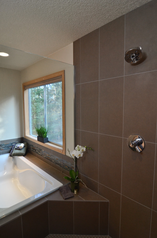 На фото: ванная комната в стиле неоклассика (современная классика) с врезной раковиной, фасадами в стиле шейкер, светлыми деревянными фасадами, столешницей из гранита, накладной ванной, угловым душем и серой плиткой с