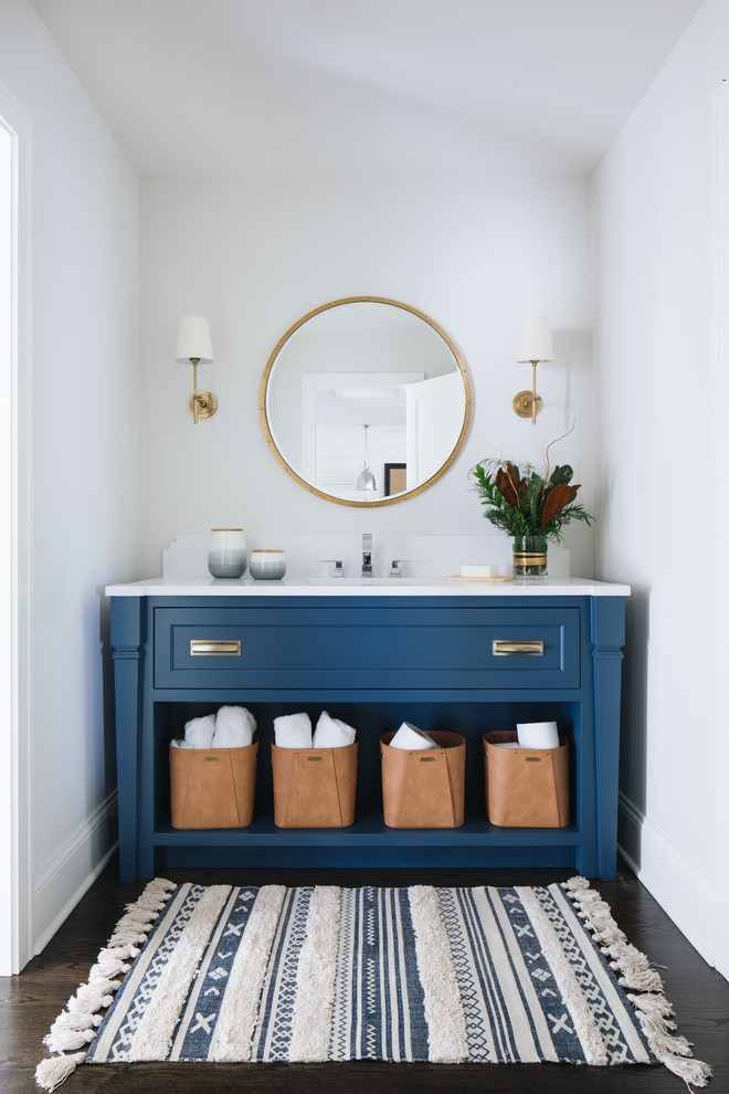 Foto de cuarto de baño principal tradicional renovado con puertas de armario azules, paredes blancas, suelo de madera oscura, lavabo bajoencimera, suelo marrón, encimeras blancas y armarios con paneles empotrados