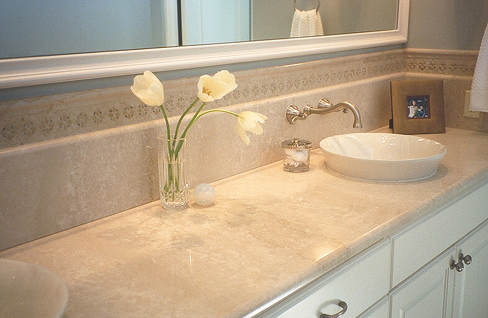 Esempio di una stanza da bagno classica con lavabo a bacinella, ante con bugna sagomata, ante bianche, top in pietra calcarea, WC a due pezzi, piastrelle beige, piastrelle in pietra, pareti blu e pavimento in travertino