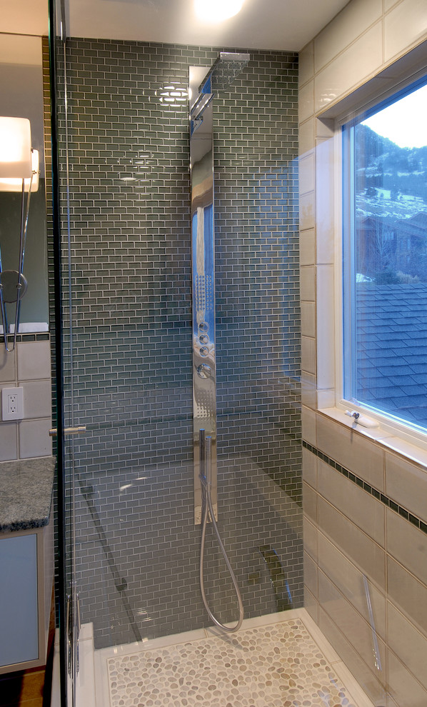 Immagine di una stanza da bagno minimal con lavabo a bacinella, ante lisce, ante in legno chiaro, top in granito, vasca da incasso, doccia ad angolo, piastrelle verdi e piastrelle di vetro