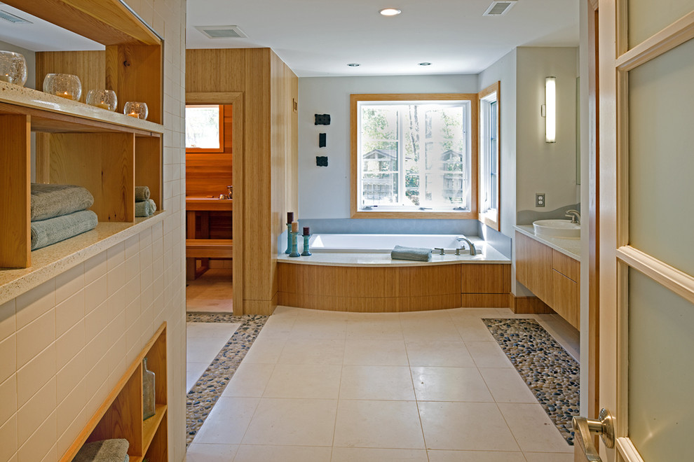 Exempel på ett mellanstort modernt en-suite badrum, med klinkergolv i småsten, släta luckor, skåp i ljust trä, en öppen dusch, en toalettstol med hel cisternkåpa, vit kakel, stenhäll, blå väggar, ett fristående handfat, bänkskiva i akrylsten och ett platsbyggt badkar
