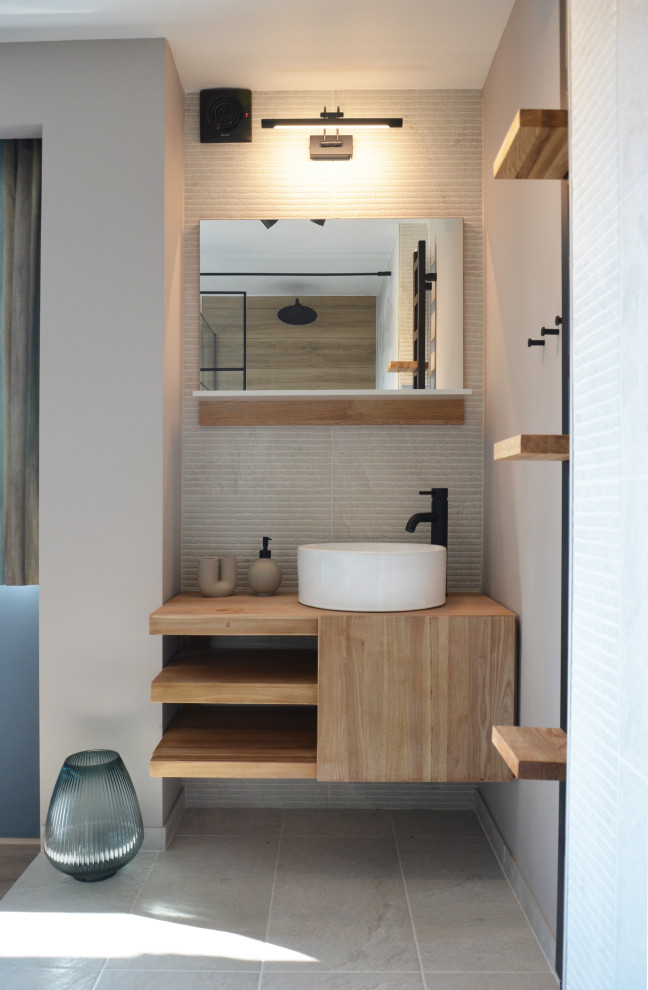 Expansive contemporary ensuite wet room bathroom in Manchester with open cabinets, medium wood cabinets, beige tiles, ceramic tiles, grey walls, ceramic flooring, a vessel sink, wooden worktops, beige floors, an open shower, brown worktops, a single sink, a floating vanity unit and wood walls.