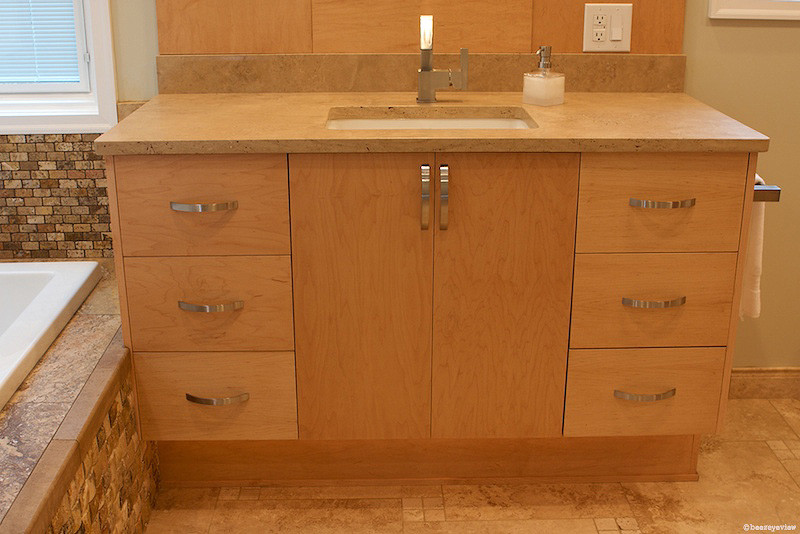 Example of a large transitional master beige tile and stone tile travertine floor bathroom design in Atlanta with an undermount sink, flat-panel cabinets, light wood cabinets, marble countertops, a two-piece toilet and beige walls