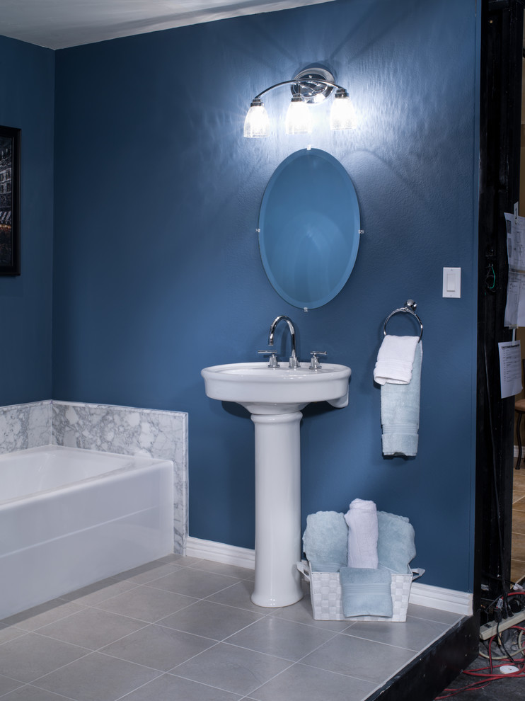 Foto di una stanza da bagno moderna con lavabo a colonna, vasca ad alcova e pareti blu