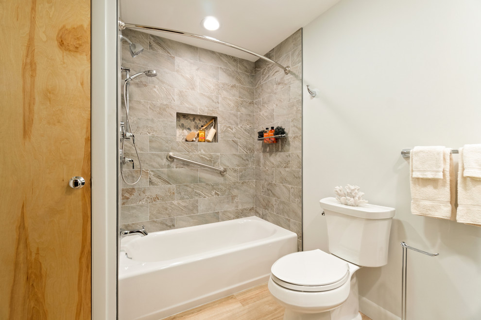 Inspiration för mellanstora klassiska flerfärgat en-suite badrum, med skåp i shakerstil, grå skåp, ett platsbyggt badkar, en dusch/badkar-kombination, en toalettstol med separat cisternkåpa, beige kakel, porslinskakel, gröna väggar, laminatgolv, ett undermonterad handfat, bänkskiva i återvunnet glas, brunt golv och dusch med duschdraperi