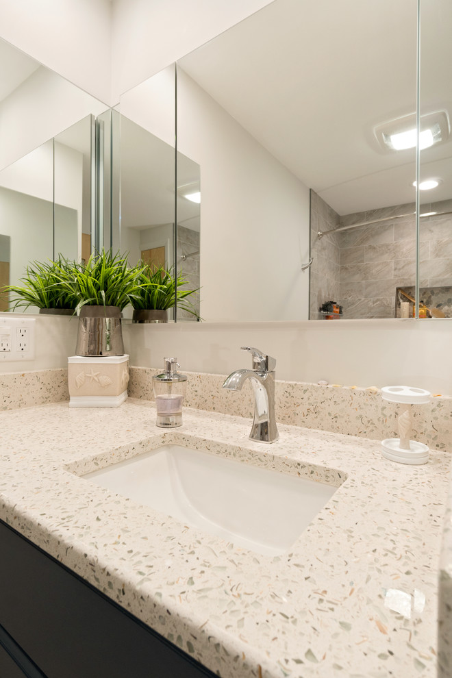 Стильный дизайн: главная ванная комната среднего размера в классическом стиле с фасадами в стиле шейкер, серыми фасадами, накладной ванной, душем над ванной, раздельным унитазом, бежевой плиткой, керамогранитной плиткой, зелеными стенами, полом из ламината, врезной раковиной, столешницей из переработанного стекла, коричневым полом, шторкой для ванной и разноцветной столешницей - последний тренд