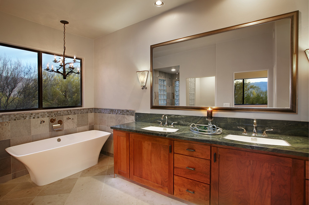 Ejemplo de cuarto de baño principal clásico renovado grande con encimera de granito, bañera exenta, ducha abierta, sanitario de una pieza, paredes grises y suelo de piedra caliza