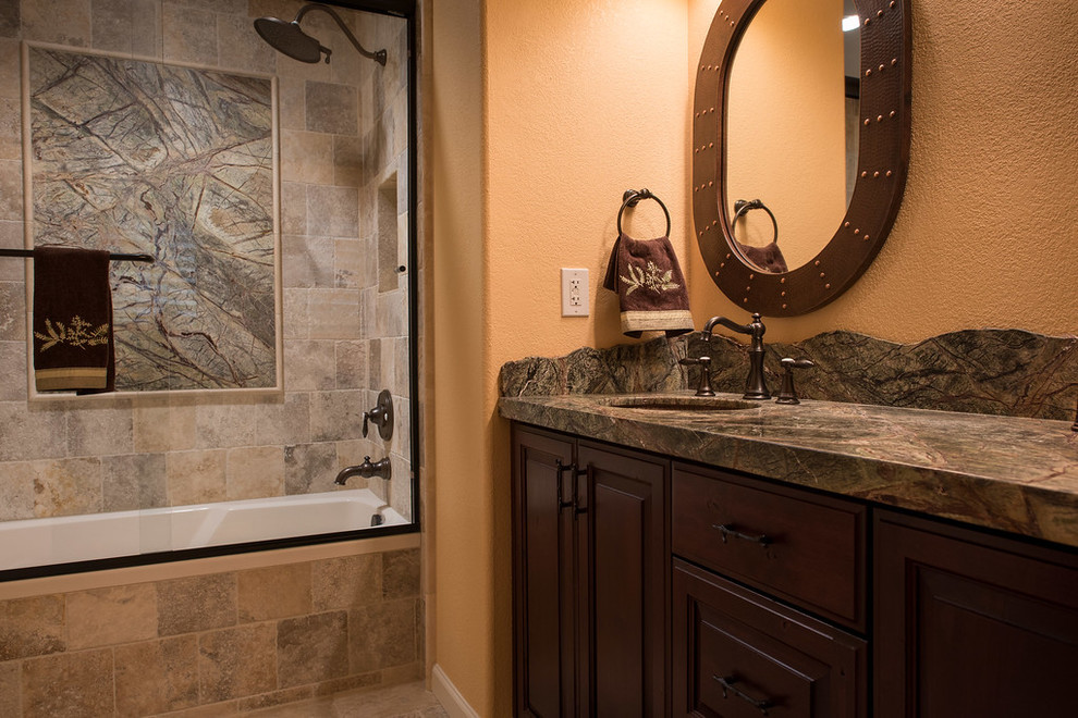 Exempel på ett litet rustikt flerfärgad flerfärgat badrum, med luckor med infälld panel, skåp i mörkt trä, ett badkar i en alkov, en dusch/badkar-kombination, en toalettstol med hel cisternkåpa, flerfärgad kakel, orange väggar, skiffergolv, ett undermonterad handfat, granitbänkskiva, beiget golv och dusch med skjutdörr
