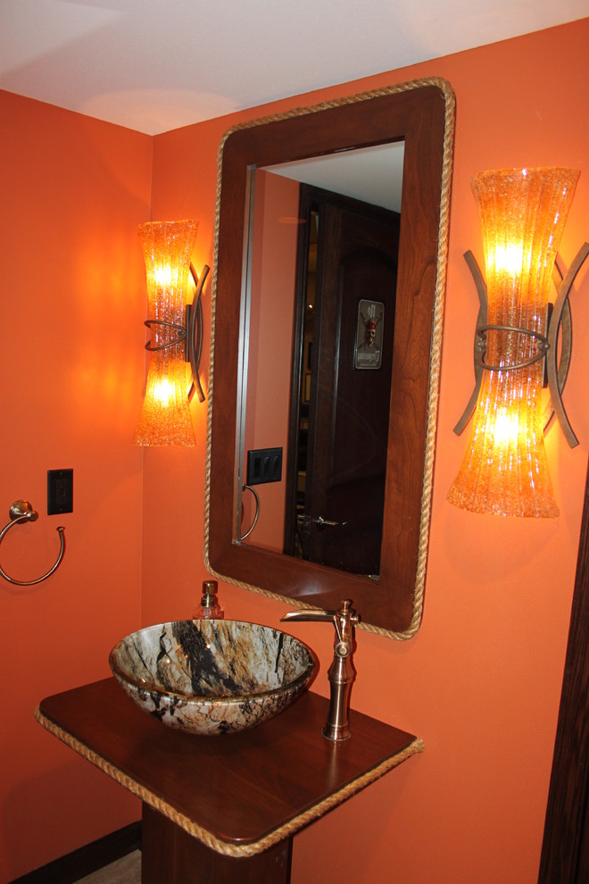 Immagine di una piccola stanza da bagno chic con lavabo a bacinella, consolle stile comò, ante in legno scuro e pareti arancioni