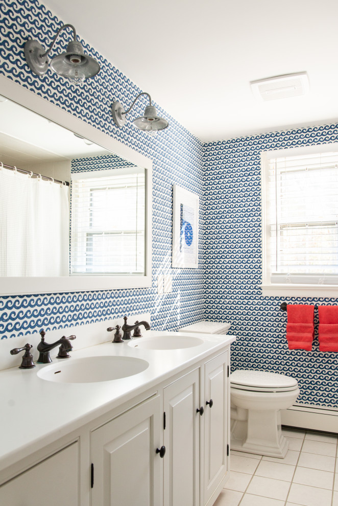 Ejemplo de cuarto de baño infantil, marinero, con armarios con paneles con relieve, puertas de armario blancas, sanitario de dos piezas, paredes multicolor, suelo blanco, ducha con cortina y encimeras blancas