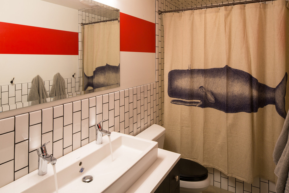 他の地域にある広いコンテンポラリースタイルのおしゃれなマスターバスルーム (横長型シンク、フラットパネル扉のキャビネット、濃色木目調キャビネット、人工大理石カウンター、アルコーブ型浴槽、シャワー付き浴槽	、分離型トイレ、白いタイル、セラミックタイル、赤い壁、コンクリートの床) の写真