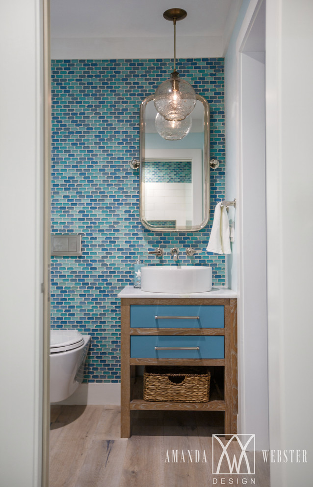 Foto di una stanza da bagno con doccia stile marinaro con nessun'anta, ante in legno scuro, piastrelle blu, piastrelle di vetro, pareti blu, parquet chiaro e lavabo a bacinella