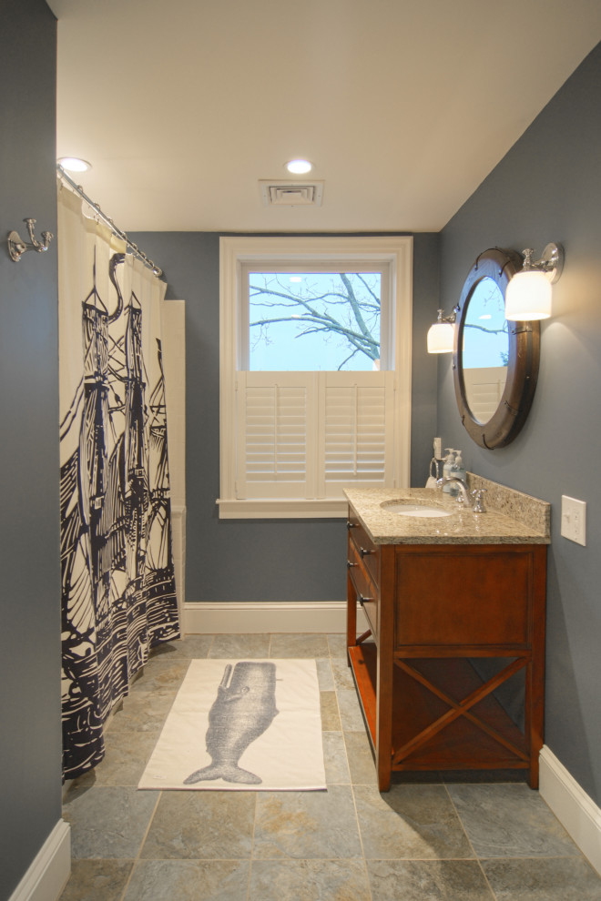 Inredning av ett klassiskt mellanstort badrum för barn, med möbel-liknande, skåp i mörkt trä, marmorbänkskiva, ett badkar i en alkov, en dusch/badkar-kombination, vit kakel, porslinskakel, blå väggar och klinkergolv i porslin