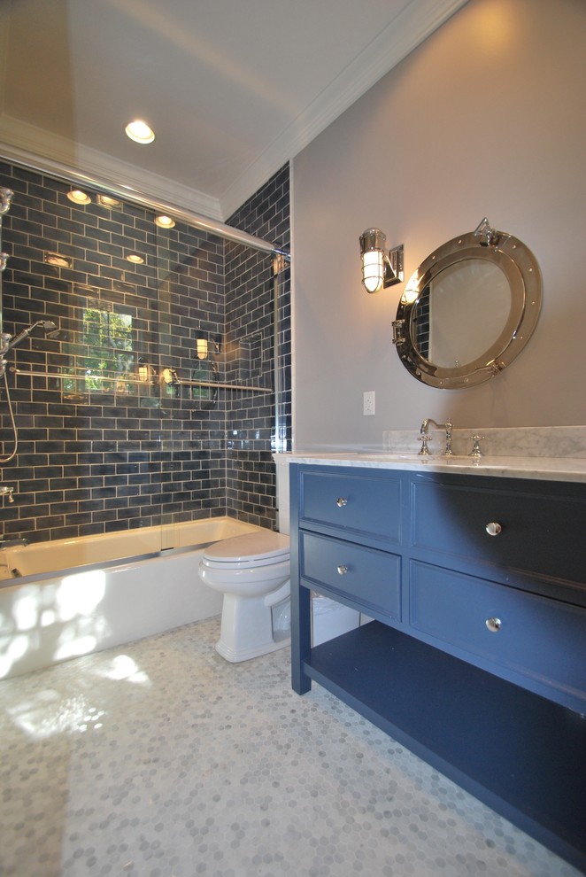 На фото: детская ванная комната среднего размера в стиле неоклассика (современная классика) с фасадами с декоративным кантом, синими фасадами, ванной в нише, душем над ванной, раздельным унитазом, синей плиткой, керамической плиткой, серыми стенами, мраморным полом, врезной раковиной, мраморной столешницей, серым полом и душем с раздвижными дверями