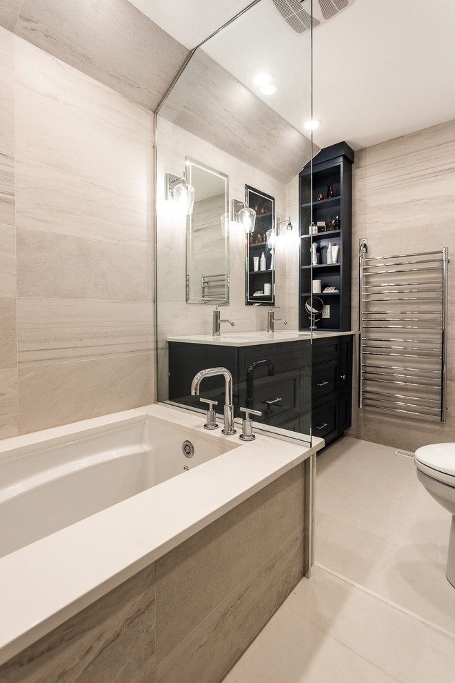 Inspiration for a medium sized contemporary ensuite bathroom in Montreal with shaker cabinets, blue cabinets, a submerged bath, a walk-in shower, a one-piece toilet, beige tiles, ceramic tiles, beige walls, ceramic flooring, a submerged sink, engineered stone worktops, beige floors and beige worktops.