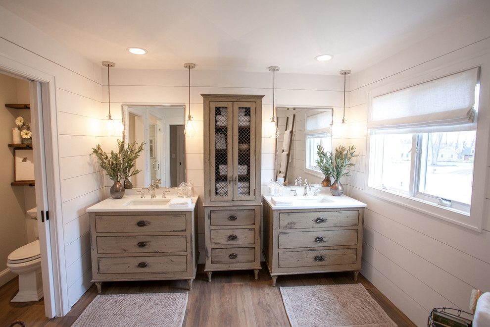 Design ideas for a large traditional ensuite bathroom in Philadelphia with freestanding cabinets, distressed cabinets, a freestanding bath, an alcove shower, a two-piece toilet, white tiles, ceramic tiles, white walls, porcelain flooring, a submerged sink, glass worktops, brown floors and a hinged door.