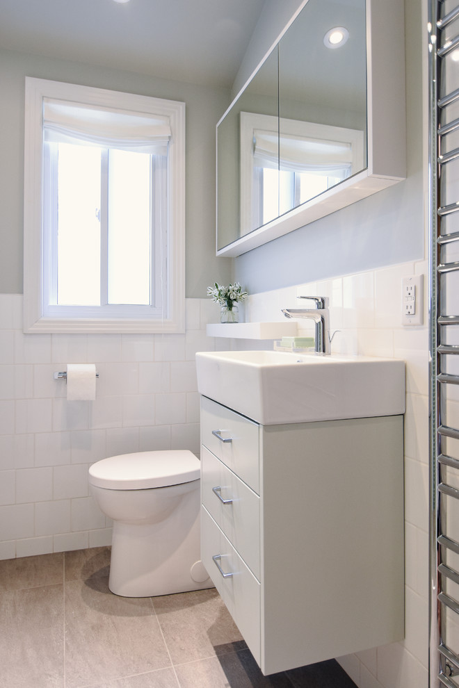 Пример оригинального дизайна: маленькая ванная комната в современном стиле с плоскими фасадами, бирюзовыми фасадами, душем без бортиков, раздельным унитазом, белой плиткой, керамической плиткой, серыми стенами, полом из керамогранита, душевой кабиной, подвесной раковиной, серым полом и душем с распашными дверями для на участке и в саду
