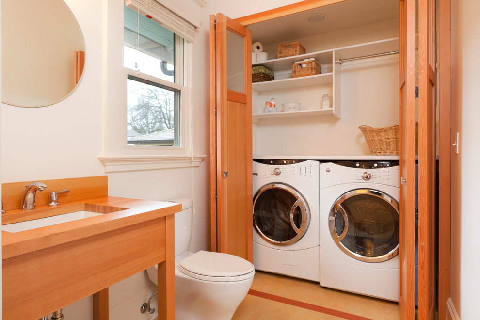 ポートランドにあるトランジショナルスタイルのおしゃれな浴室 (アンダーカウンター洗面器、木製洗面台、白い壁、ブラウンの洗面カウンター、洗濯室) の写真