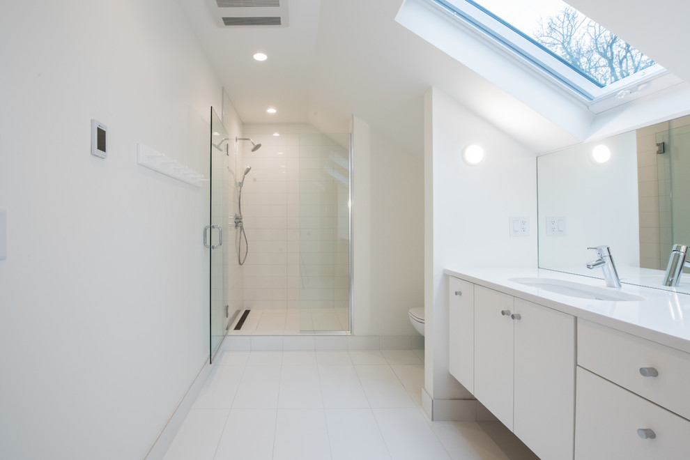 Large modern ensuite bathroom in Omaha with flat-panel cabinets, white cabinets, an alcove shower, white walls, an integrated sink, engineered stone worktops, white floors, a hinged door and porcelain flooring.