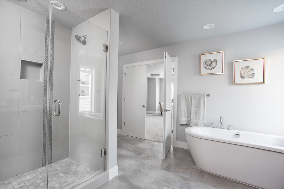 Пример оригинального дизайна: большая главная ванная комната в стиле модернизм с плоскими фасадами, темными деревянными фасадами, ванной на ножках, двойным душем, раздельным унитазом, белой плиткой, стеклянной плиткой, серыми стенами, полом из керамической плитки, накладной раковиной, столешницей из плитки, серым полом и душем с распашными дверями