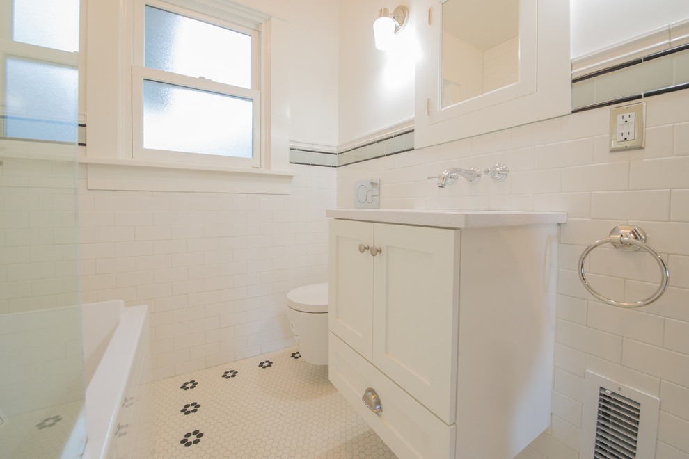 Photo of a medium sized classic shower room bathroom in Portland with shaker cabinets, white cabinets, white tiles, metro tiles, engineered stone worktops, white worktops, an alcove bath, a shower/bath combination, a submerged sink, an open shower, a wall mounted toilet, white walls, porcelain flooring and multi-coloured floors.