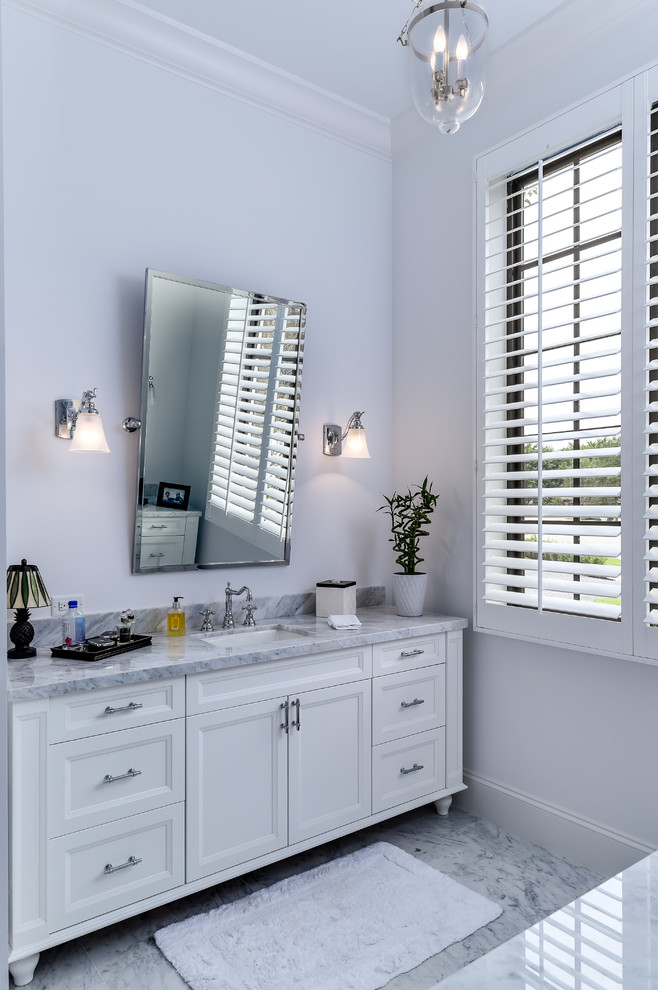 Imagen de cuarto de baño principal clásico renovado de tamaño medio con armarios con paneles empotrados, puertas de armario blancas, suelo de mármol y encimera de mármol
