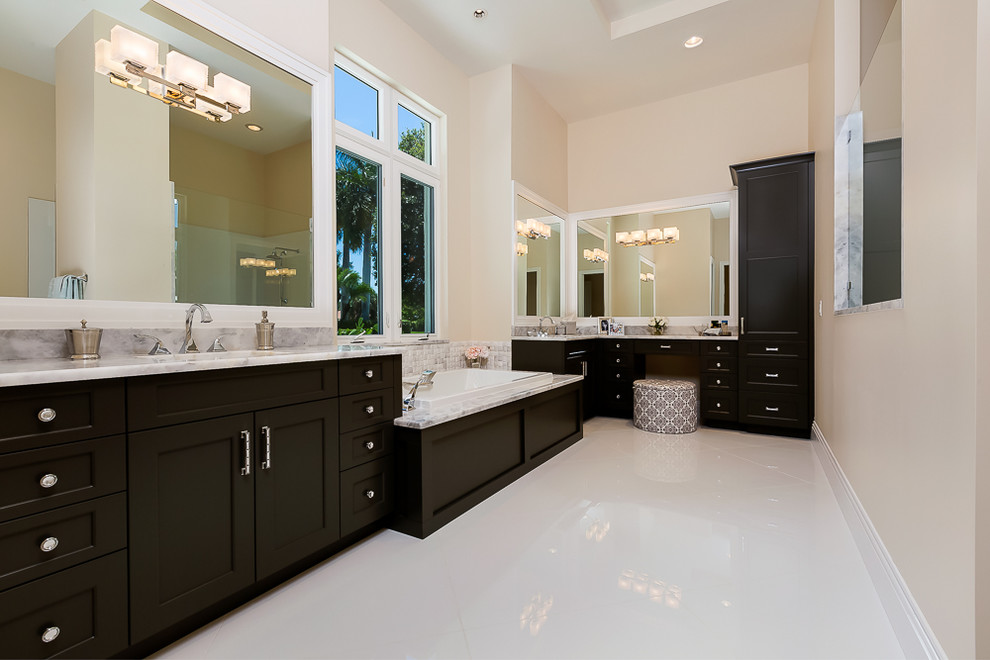 Inspiration for a large tropical master white tile and ceramic tile ceramic tile and white floor drop-in bathtub remodel in Miami with a drop-in sink, flat-panel cabinets, dark wood cabinets, quartz countertops and beige walls