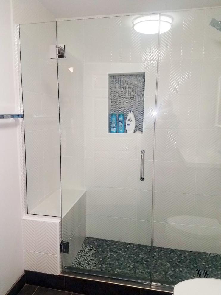 Design ideas for a large modern shower room bathroom in Chicago with flat-panel cabinets, grey cabinets, an alcove shower, a one-piece toilet, white tiles, ceramic tiles, grey walls, porcelain flooring, an integrated sink, solid surface worktops, black floors and a hinged door.
