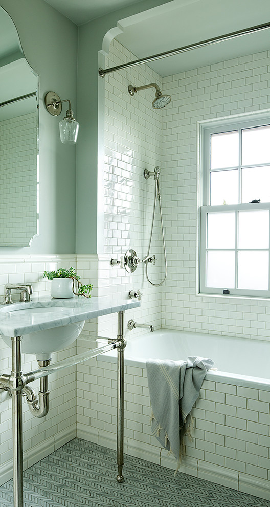 На фото: ванная комната в стиле неоклассика (современная классика) с ванной в нише, белой плиткой, плиткой кабанчик, серыми стенами, полом из мозаичной плитки, врезной раковиной, серым полом и белой столешницей