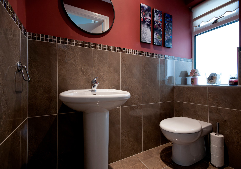 Ejemplo de cuarto de baño moderno pequeño con lavabo con pedestal, sanitario de una pieza, baldosas y/o azulejos marrones, baldosas y/o azulejos de cerámica, paredes rojas y suelo de baldosas de cerámica