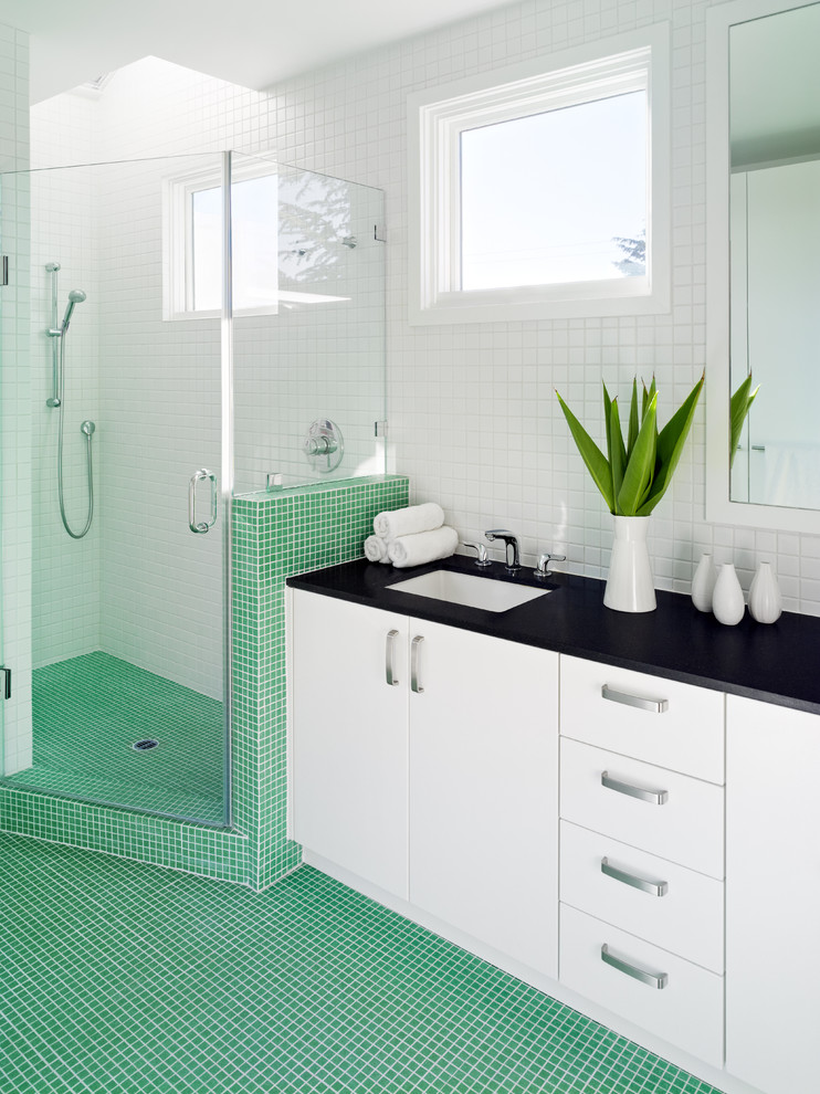 Immagine di una stanza da bagno moderna di medie dimensioni con ante lisce, ante bianche, doccia ad angolo, WC a due pezzi, piastrelle verdi, piastrelle a mosaico, pareti bianche, pavimento con piastrelle a mosaico, lavabo sottopiano e top in granito