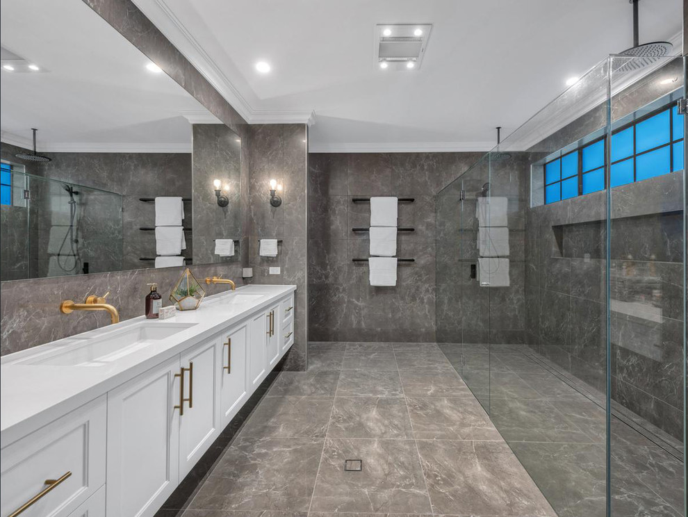 Exempel på ett vit vitt badrum med dusch, med luckor med infälld panel, vita skåp, en kantlös dusch, grå kakel, ett undermonterad handfat, grått golv och dusch med gångjärnsdörr
