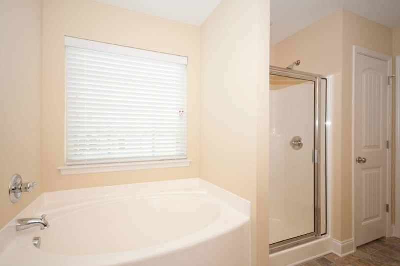 Imagen de cuarto de baño contemporáneo con lavabo integrado, puertas de armario de madera en tonos medios, ducha empotrada y sanitario de dos piezas