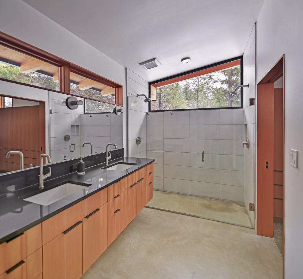 Exemple d'une salle de bain principale moderne en bois brun de taille moyenne avec un placard à porte plane, une douche à l'italienne, un carrelage blanc, des carreaux de céramique, un mur blanc, sol en béton ciré, un lavabo encastré, un plan de toilette en quartz modifié, un sol gris et une cabine de douche à porte battante.