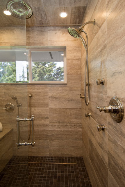 Klassisk inredning av ett badrum, med släta luckor, skåp i mörkt trä, ett fristående badkar, en kantlös dusch, porslinskakel, ett undermonterad handfat och bänkskiva i kvarts
