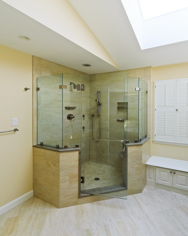 Cette photo montre une salle de bain principale chic en bois foncé de taille moyenne avec un placard en trompe-l'oeil, une douche d'angle, WC séparés, un carrelage beige, des carreaux de porcelaine, un mur beige, un sol en carrelage de porcelaine, un lavabo encastré et un plan de toilette en marbre.