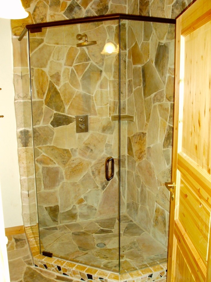 Diseño de cuarto de baño principal con puertas de armario de madera clara, ducha esquinera y baldosas y/o azulejos beige