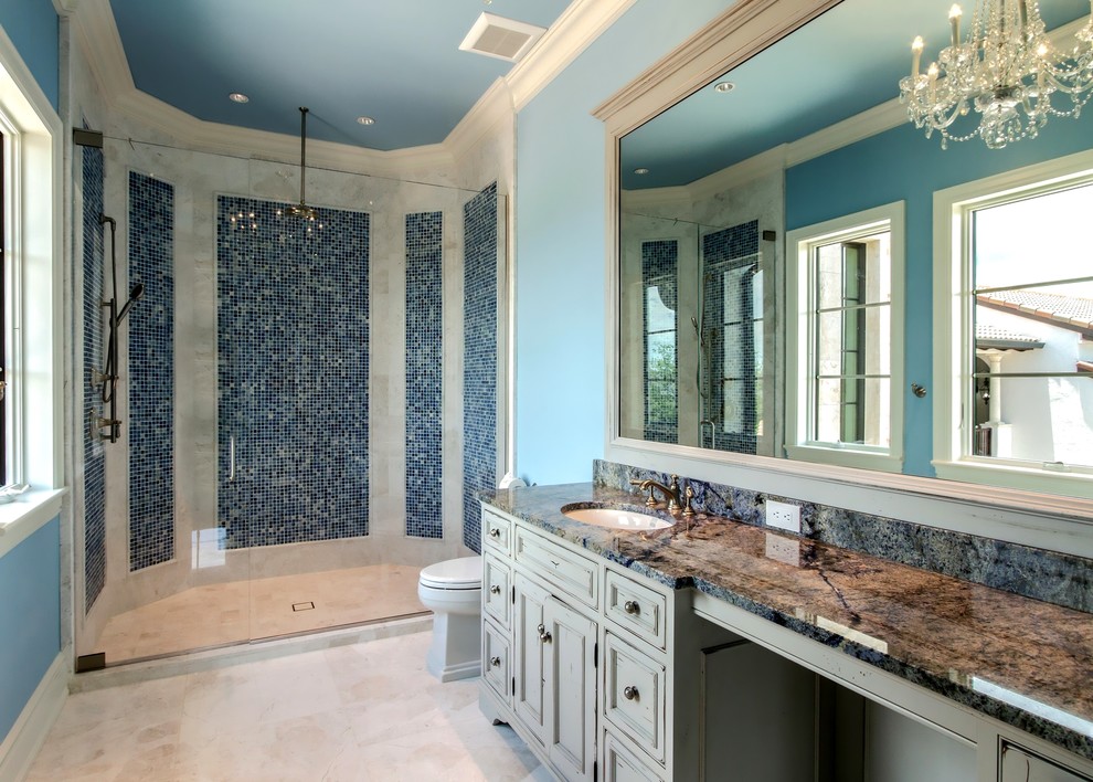 Alcove shower - mid-sized rustic kids' blue tile and mosaic tile travertine floor and beige floor alcove shower idea in Miami with furniture-like cabinets, gray cabinets, a two-piece toilet, blue walls, an undermount sink, granite countertops, a hinged shower door and multicolored countertops