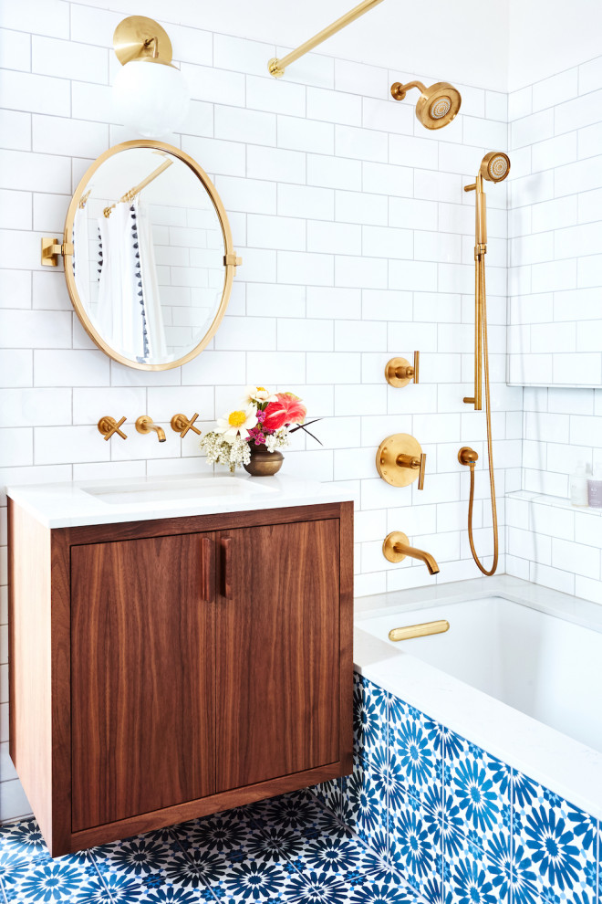 Foto på ett vintage vit badrum, med släta luckor, skåp i mellenmörkt trä, ett undermonterat badkar, en dusch/badkar-kombination, vit kakel, vita väggar, cementgolv, ett undermonterad handfat, brunt golv och dusch med duschdraperi