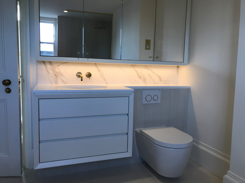 Esempio di una stanza da bagno per bambini minimalista di medie dimensioni con ante bianche, pavimento in gres porcellanato, top in quarzo composito, pavimento bianco e top bianco