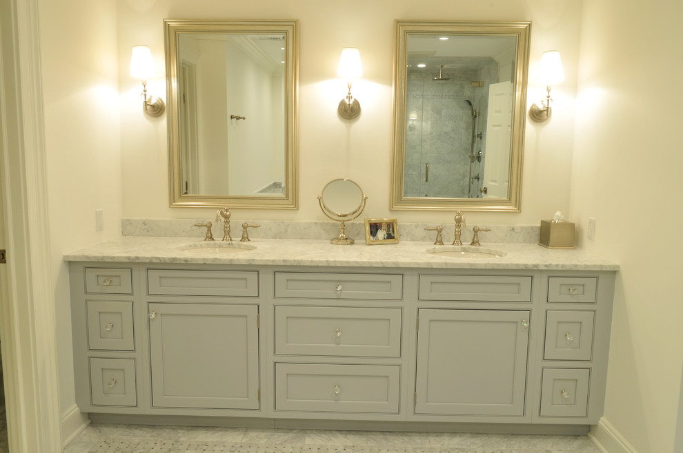 Exemple d'une salle de bain principale chic de taille moyenne avec un lavabo encastré, un placard avec porte à panneau encastré, des portes de placard grises, un plan de toilette en marbre, une baignoire posée, une douche d'angle, WC séparés, un carrelage gris, un carrelage de pierre, un mur gris et un sol en marbre.