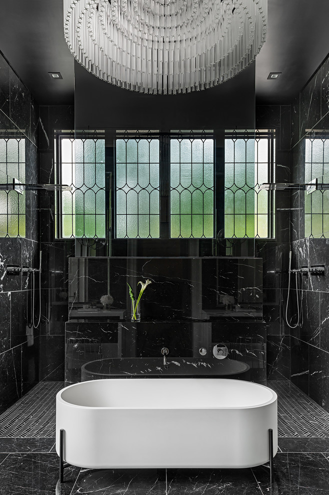 Idée de décoration pour une salle de bain principale méditerranéenne avec une baignoire indépendante, une douche double, un carrelage noir, un mur noir, un sol noir et une fenêtre.