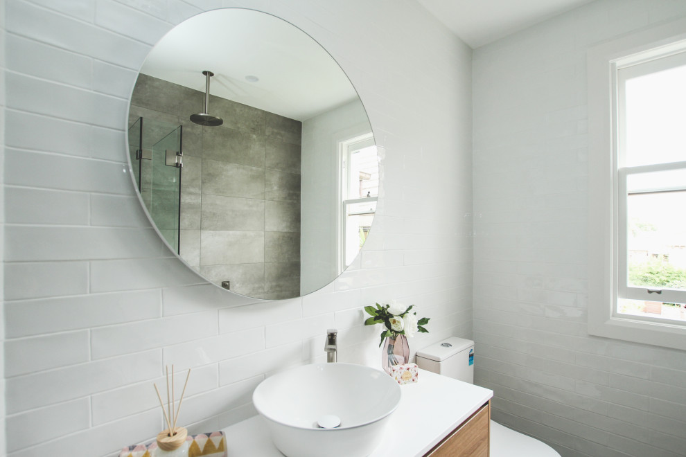 Exempel på ett mellanstort nordiskt vit vitt en-suite badrum, med skåp i mellenmörkt trä, ett platsbyggt badkar, en dusch/badkar-kombination, en toalettstol med separat cisternkåpa, vit kakel, vita väggar, klinkergolv i porslin, ett konsol handfat, grått golv och dusch med gångjärnsdörr