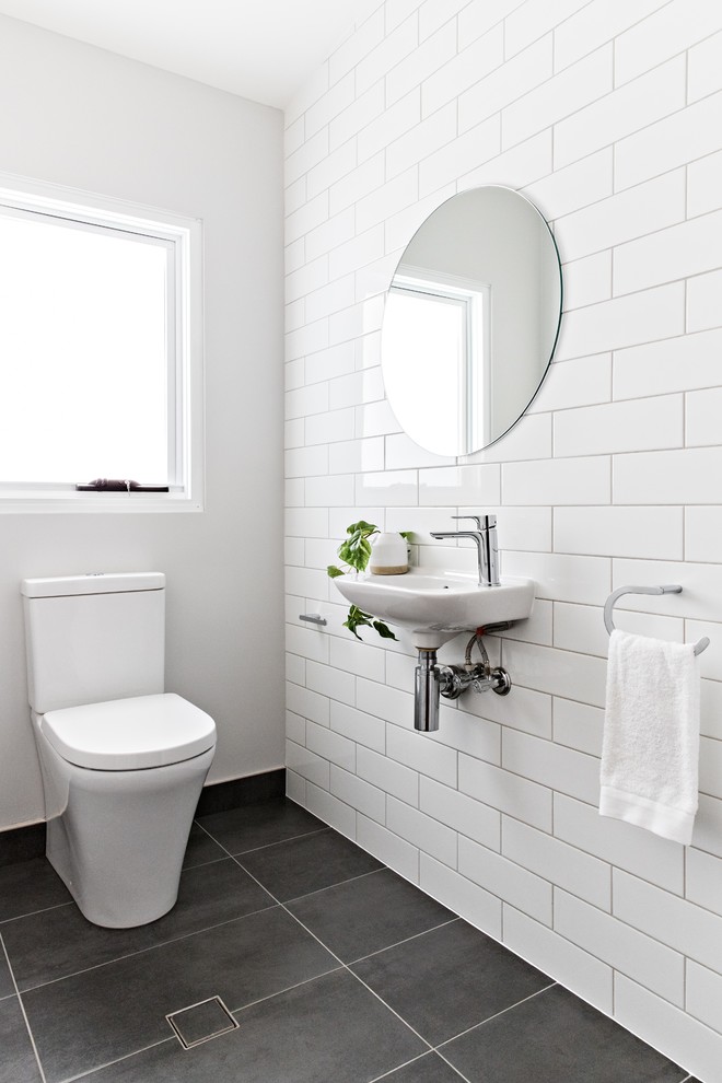 Idéer för ett modernt badrum, med en toalettstol med separat cisternkåpa, vit kakel, vita väggar, ett väggmonterat handfat och grått golv