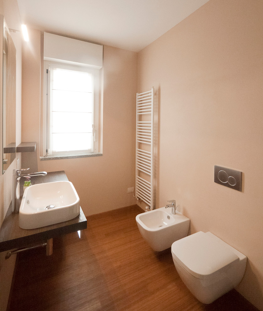 На фото: главная ванная комната среднего размера в стиле модернизм с консольной раковиной, столешницей из дерева, угловым душем, раздельным унитазом, коричневой плиткой, плиткой мозаикой, бежевыми стенами и полом из бамбука с